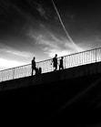 a group of people walking across a bridge