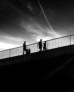 a group of people walking across a bridge