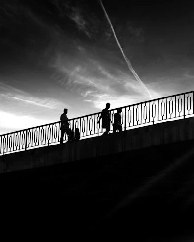 a group of people walking across a bridge