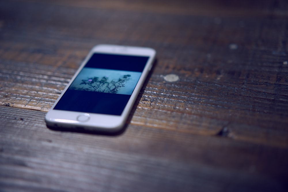 a cell phone sitting on top of a wooden table