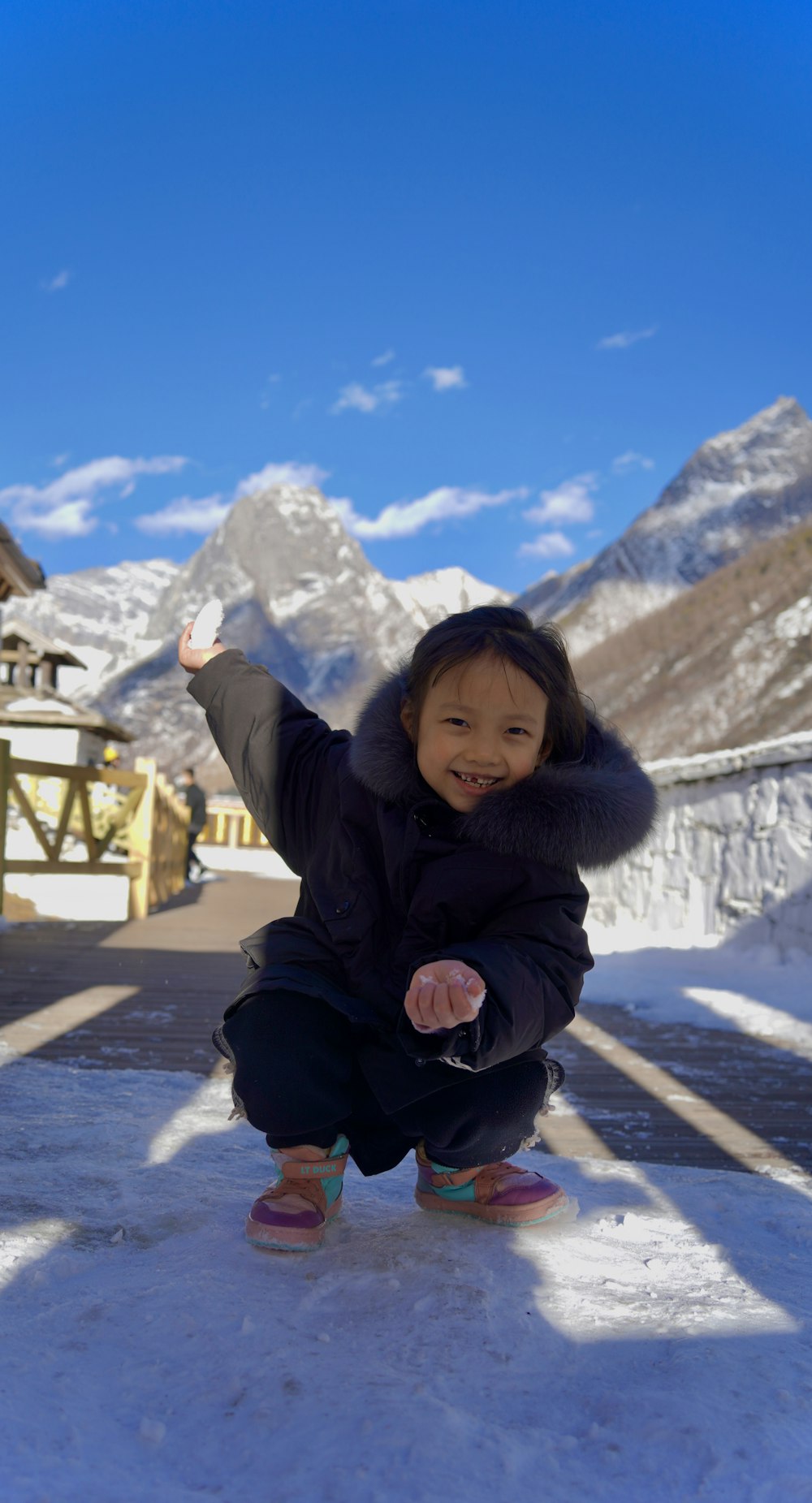 a little girl that is kneeling down in the snow