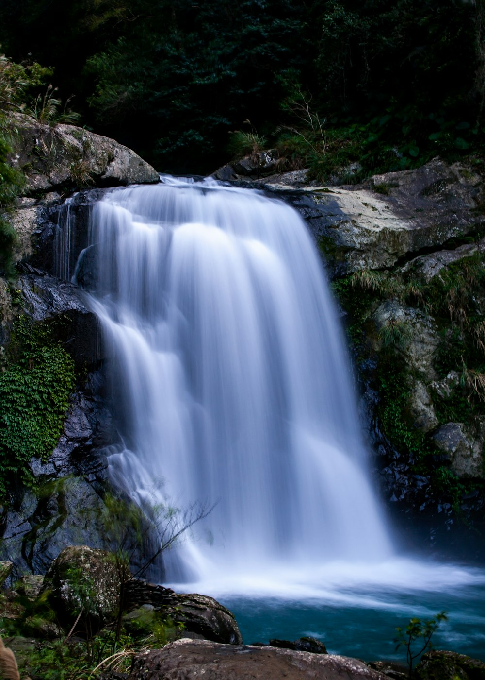 Ein großer Wasserfall mit einem Mann daneben