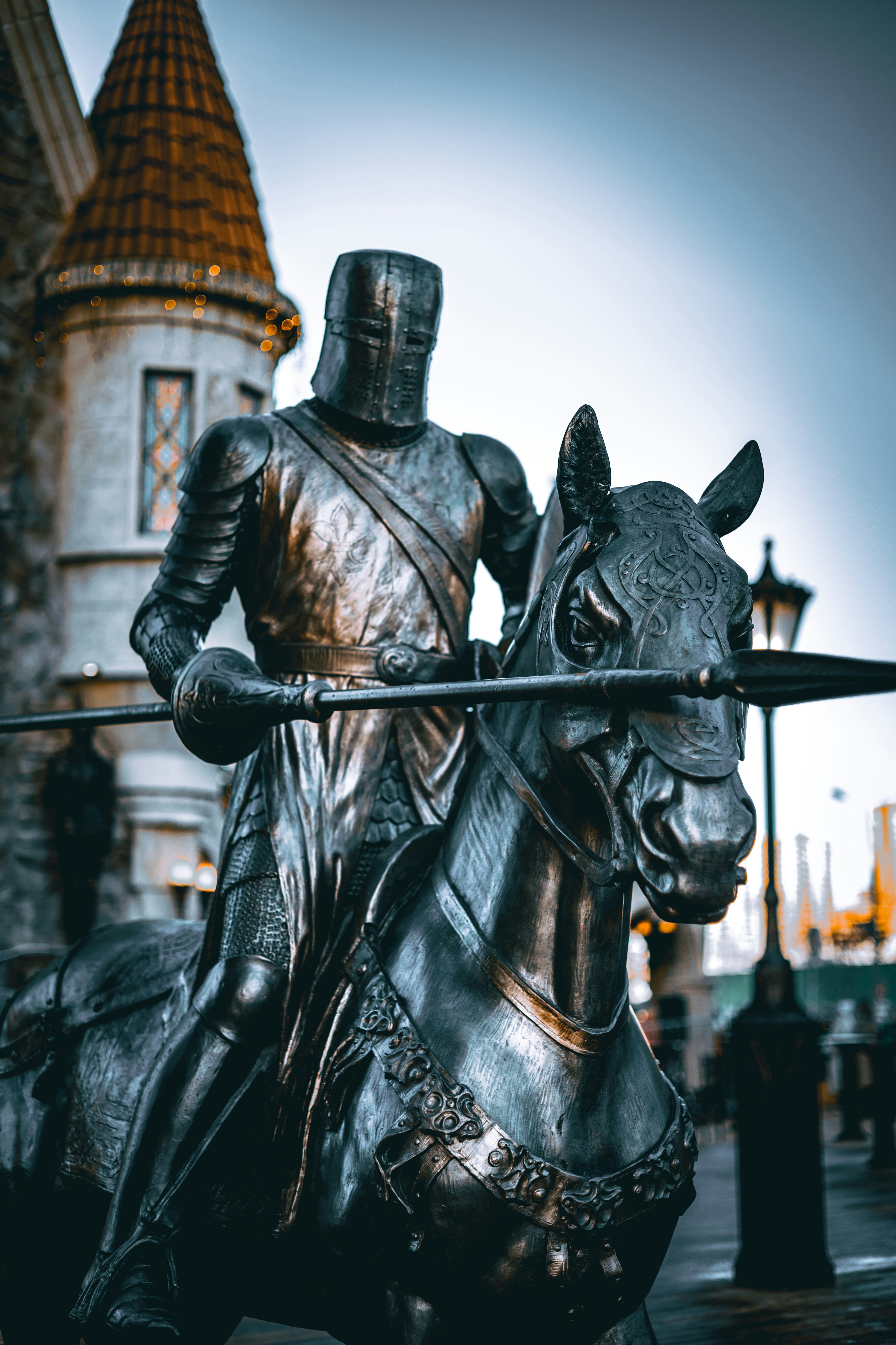 a statue of a knight on a horse in front of a castle