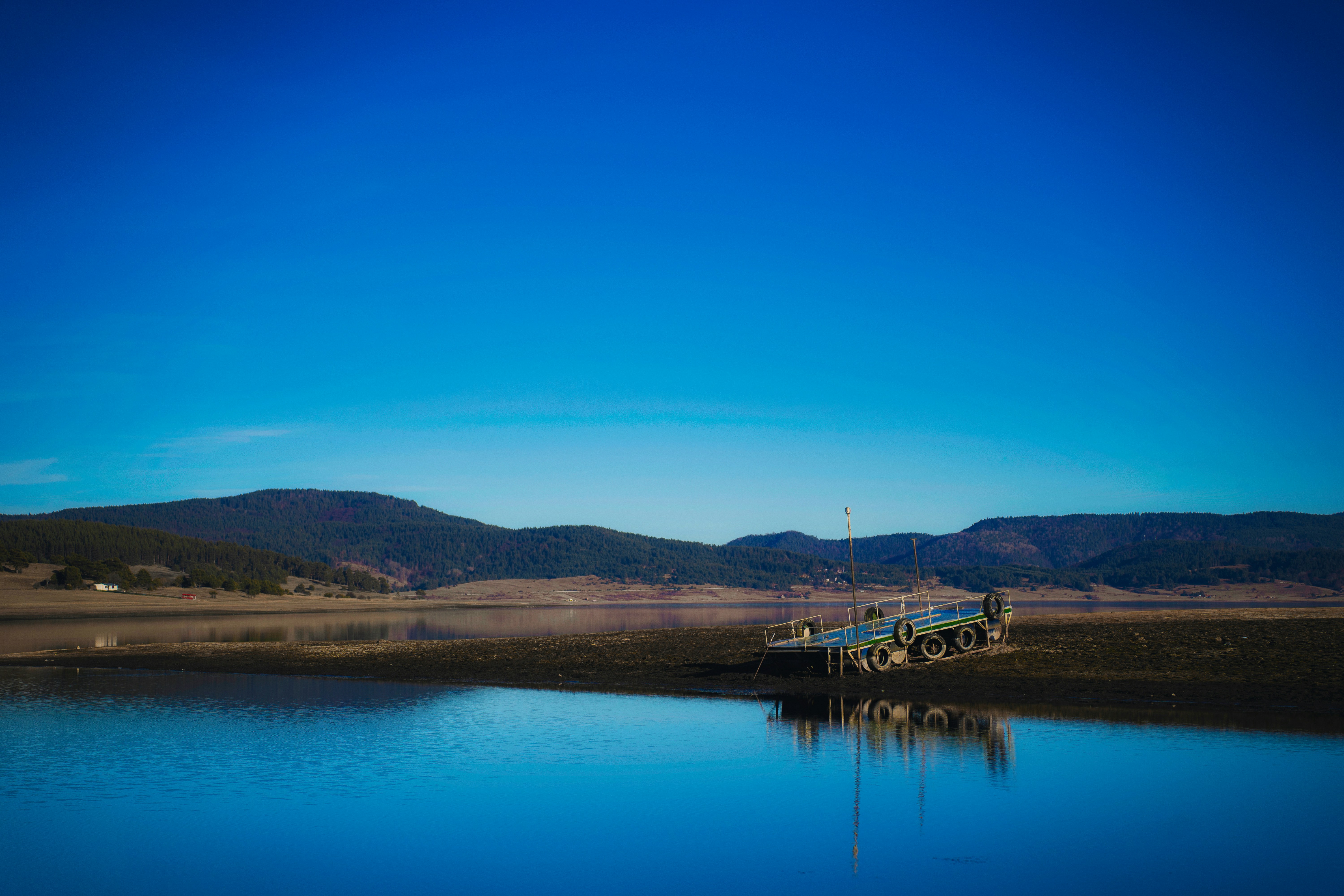 a truck is parked on the shore of a lake