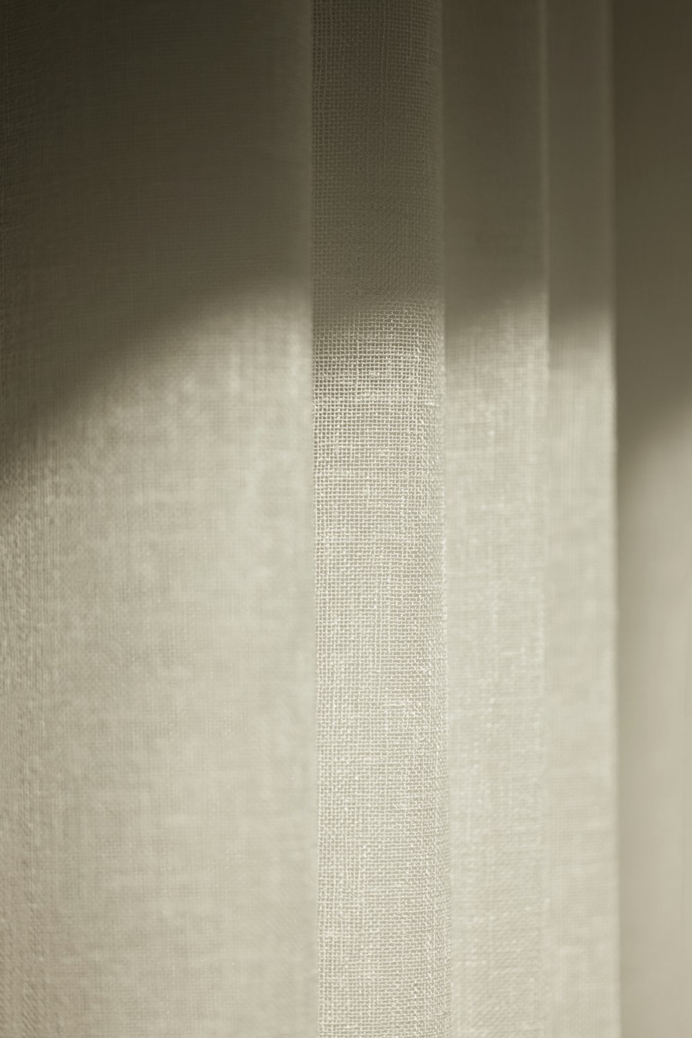 a close up of a white curtain with a light shining on it