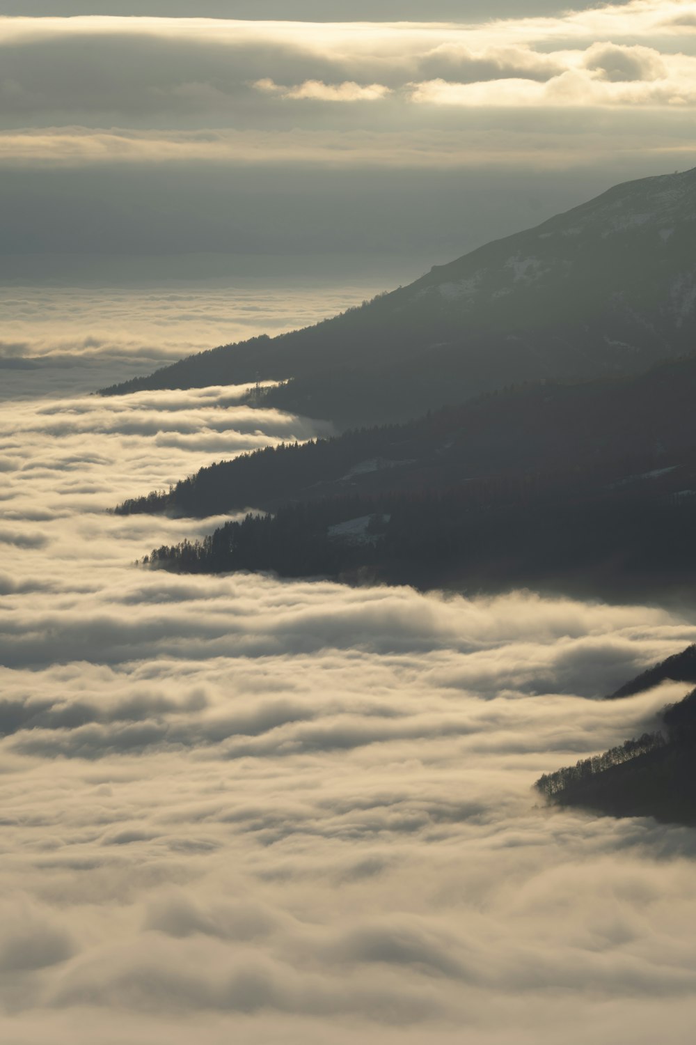 a view of a mountain covered in low lying clouds