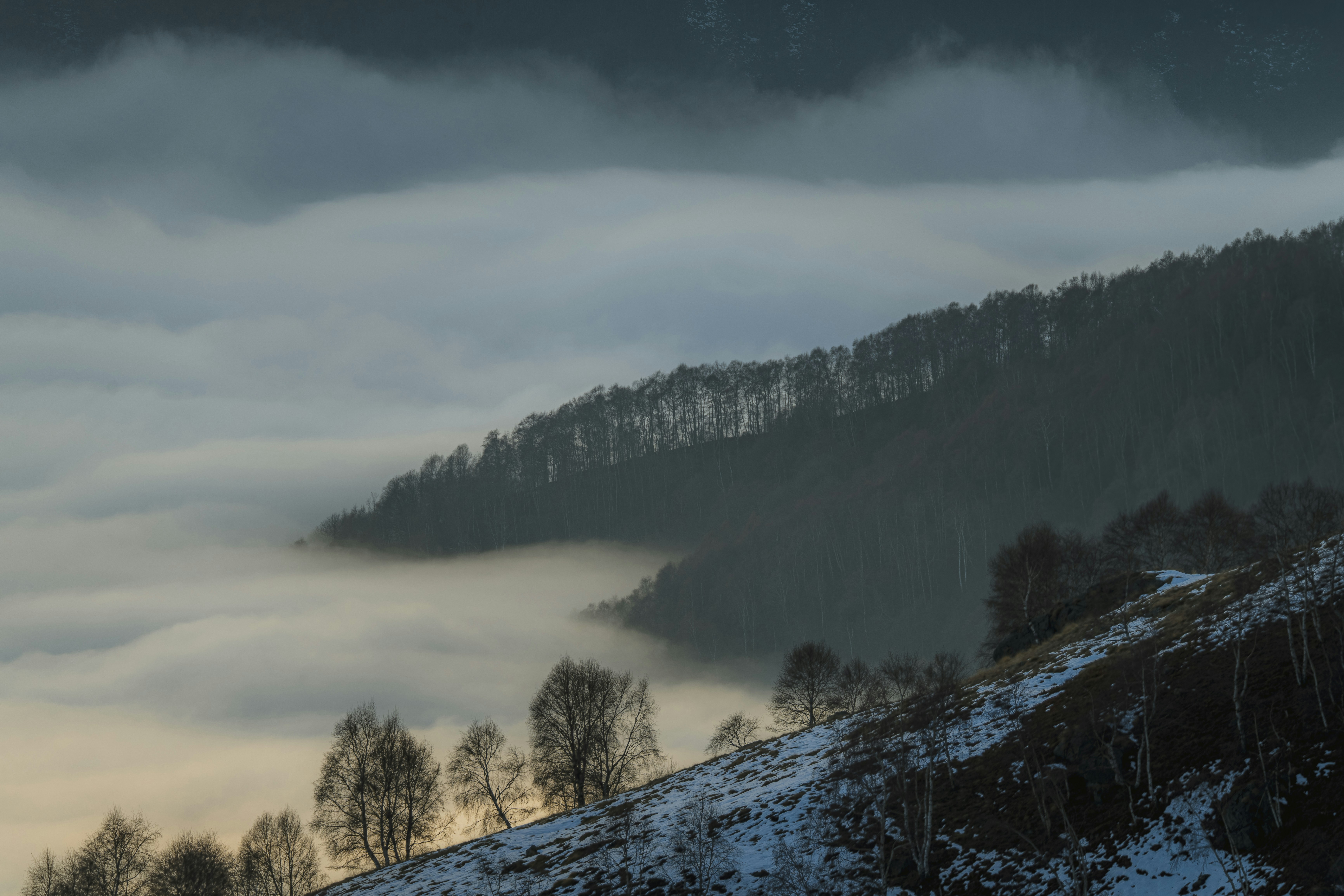 a mountain covered in fog and low lying clouds