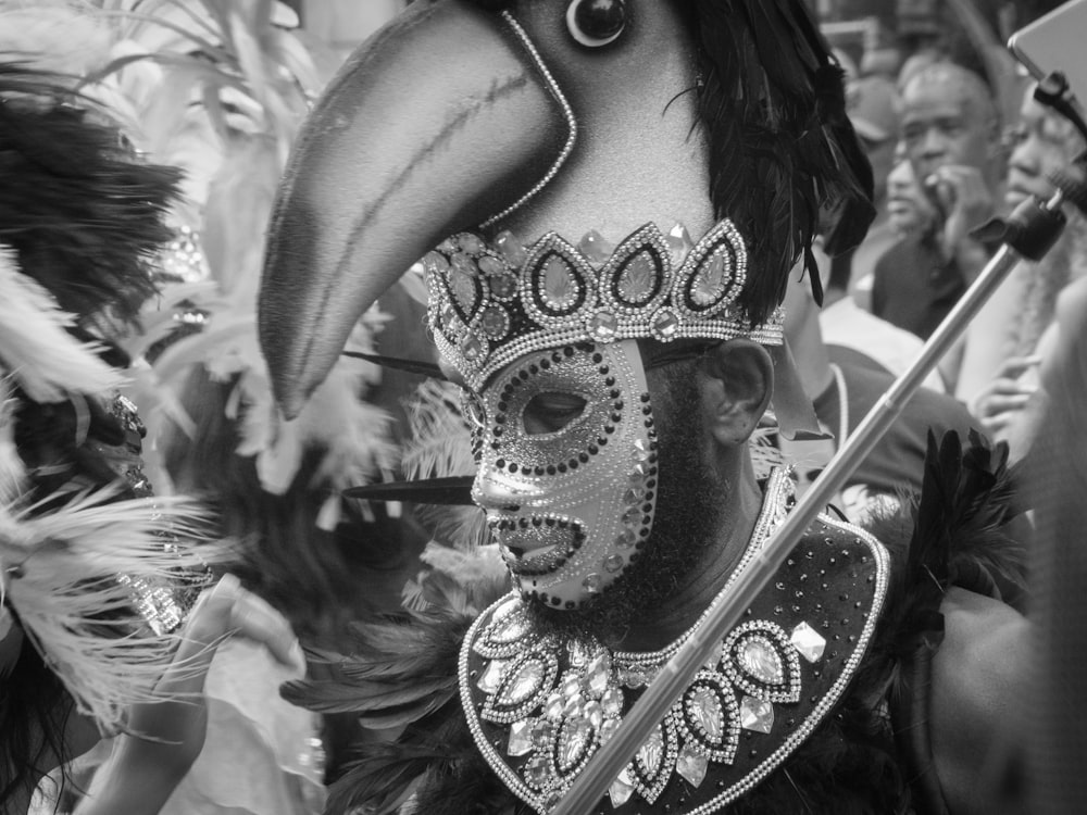 a man wearing a mask and a feathered headdress