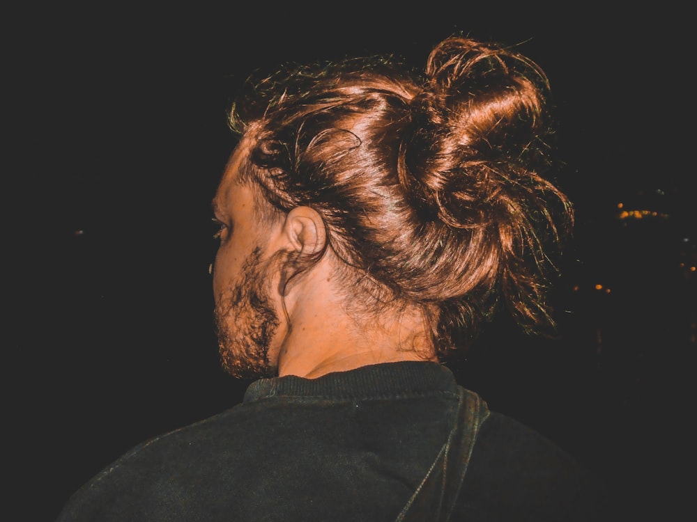 a man with a messy bun in his hair