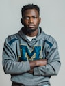 a man with his arms crossed posing for a picture