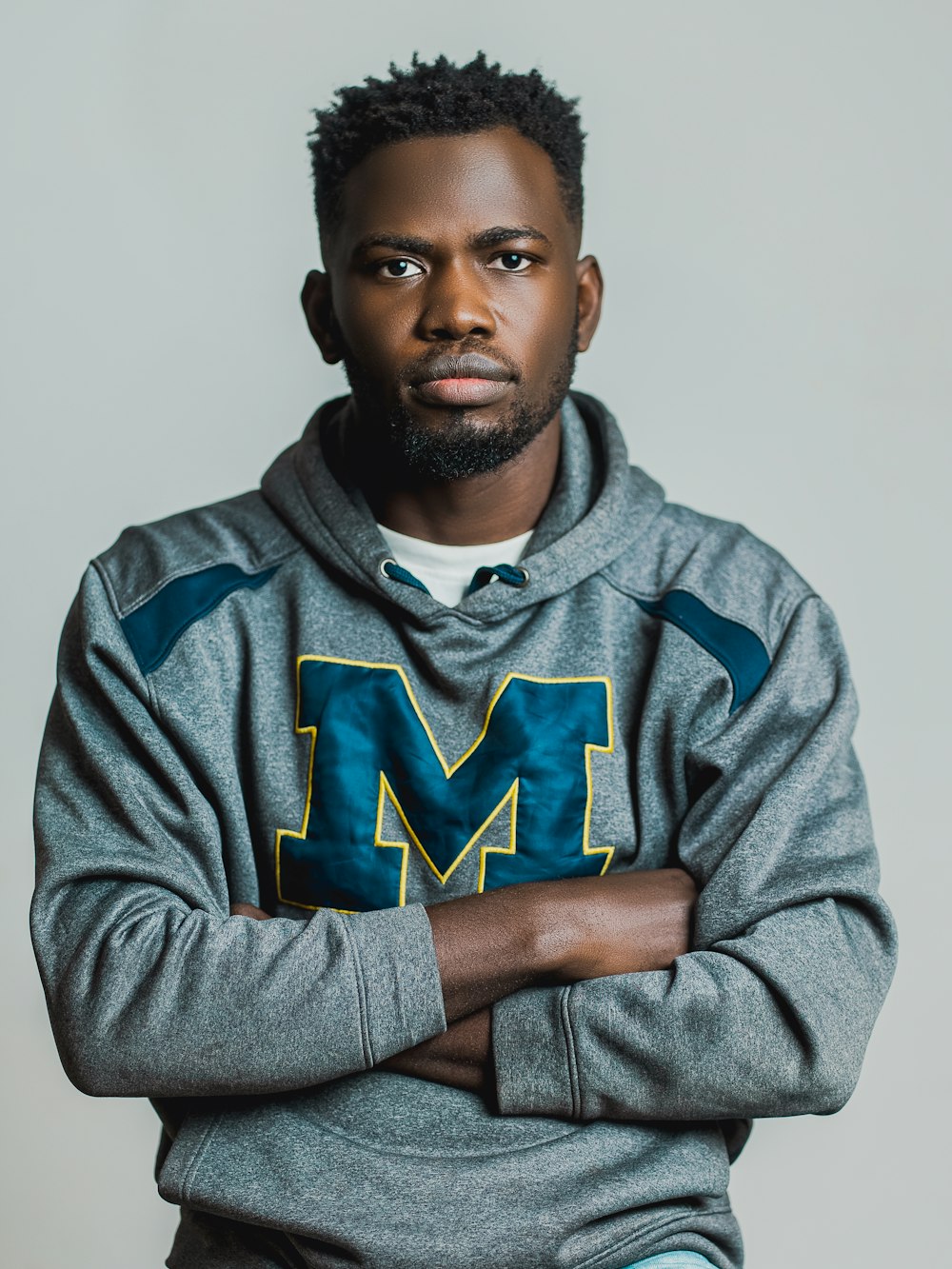 a man with his arms crossed posing for a picture