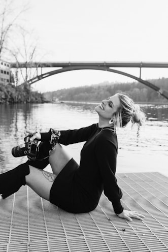 a woman sitting on the ground with a skateboard