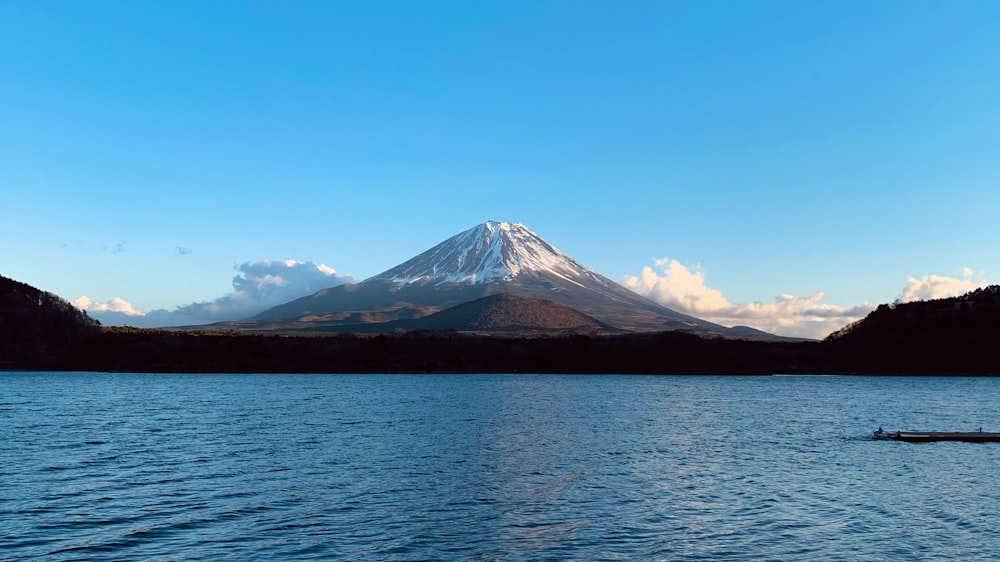 a large body of water with a mountain in the background