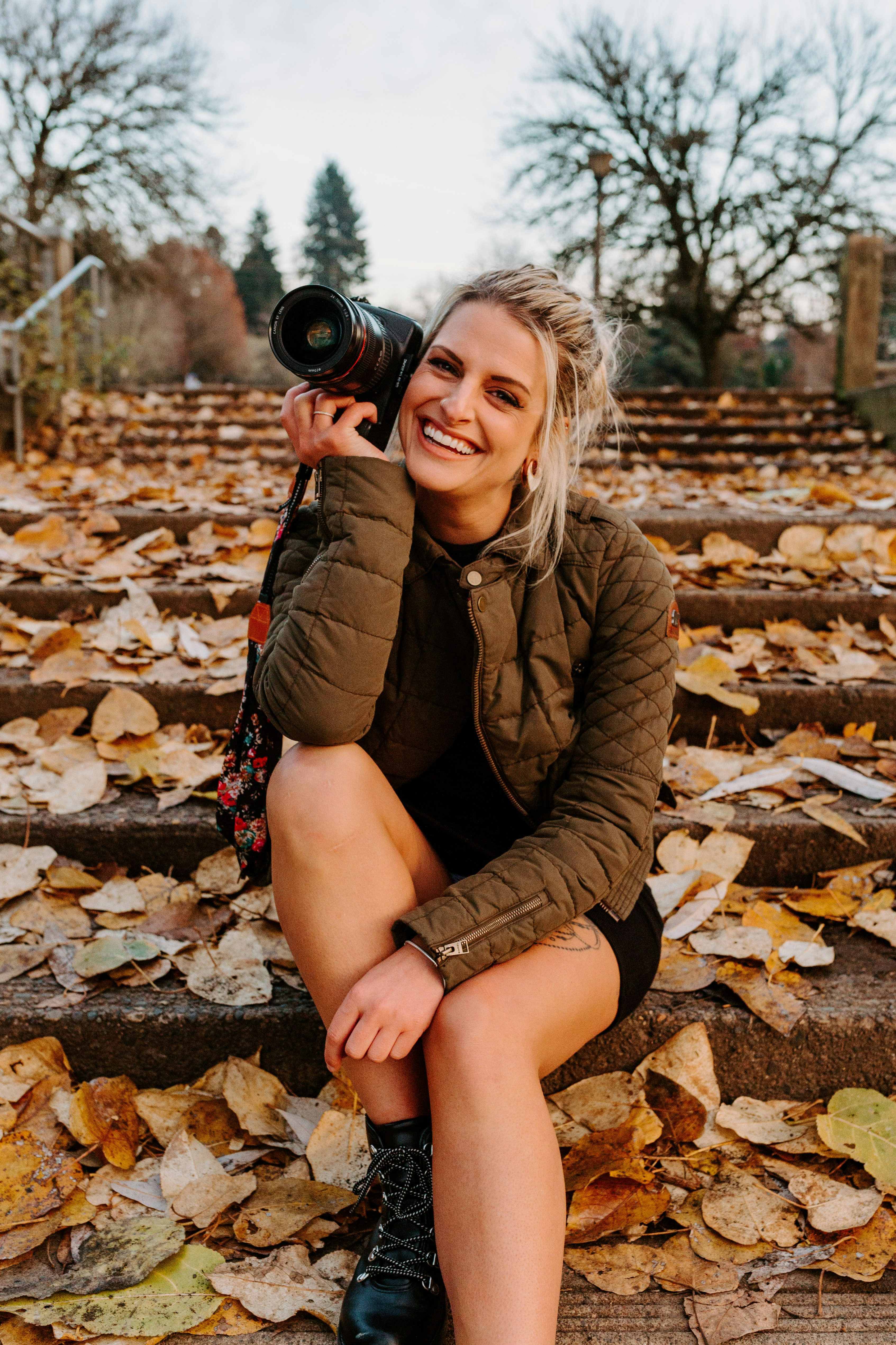 Mara Quinn sitting on stone steps with her camera