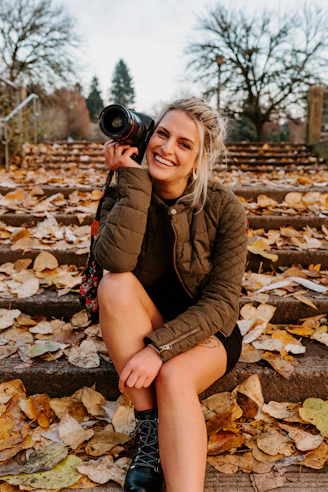a woman sitting on steps holding a camera