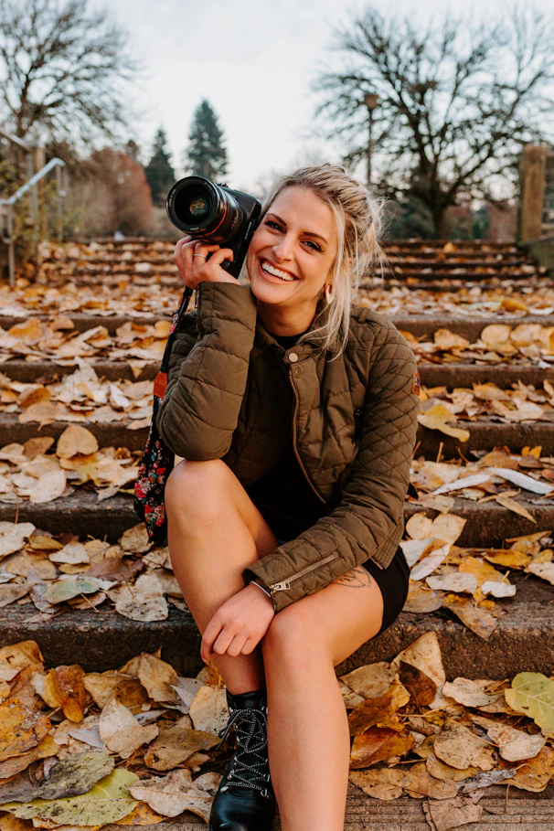 a woman sitting on steps holding a camera