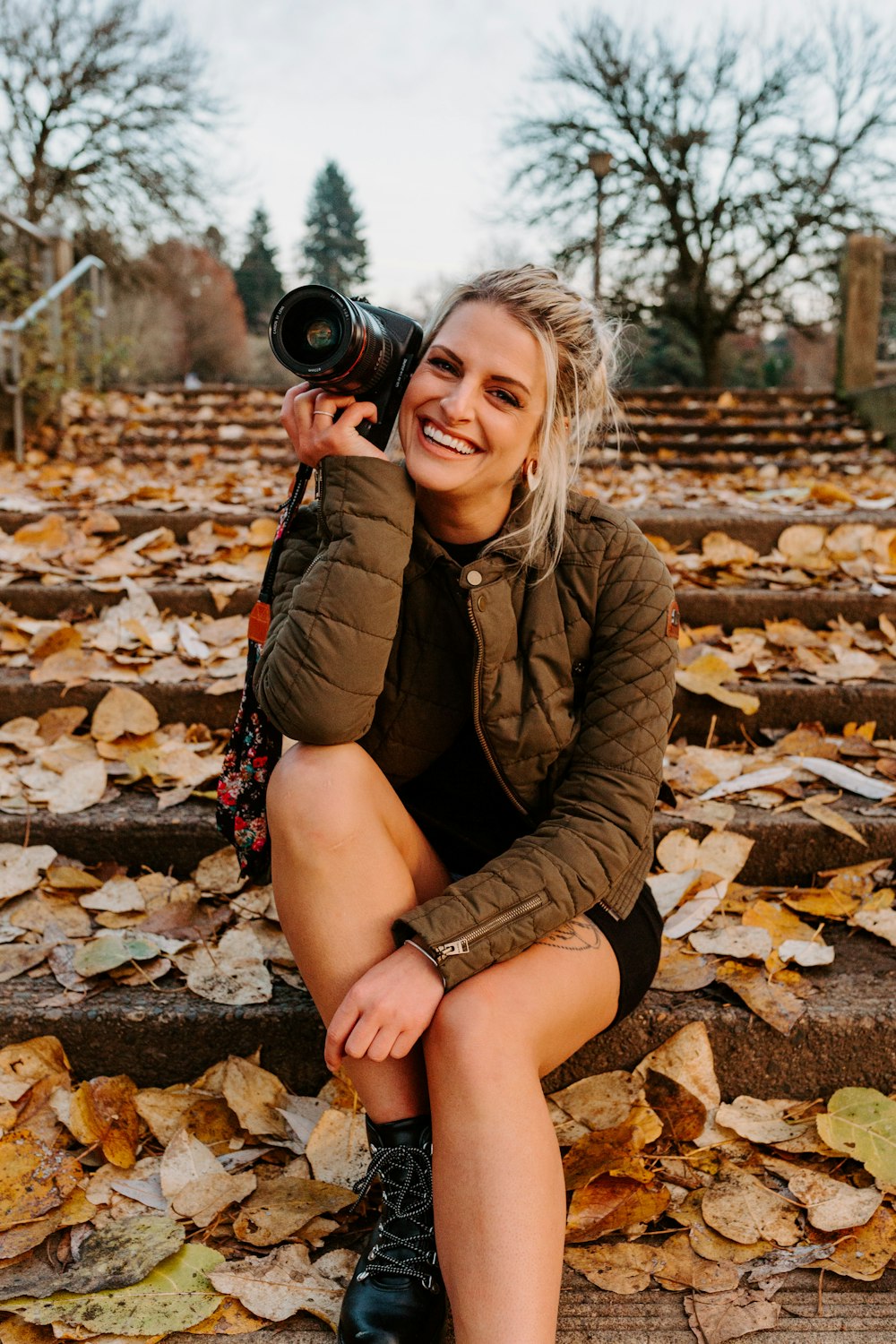 a woman sitting on steps holding a camera