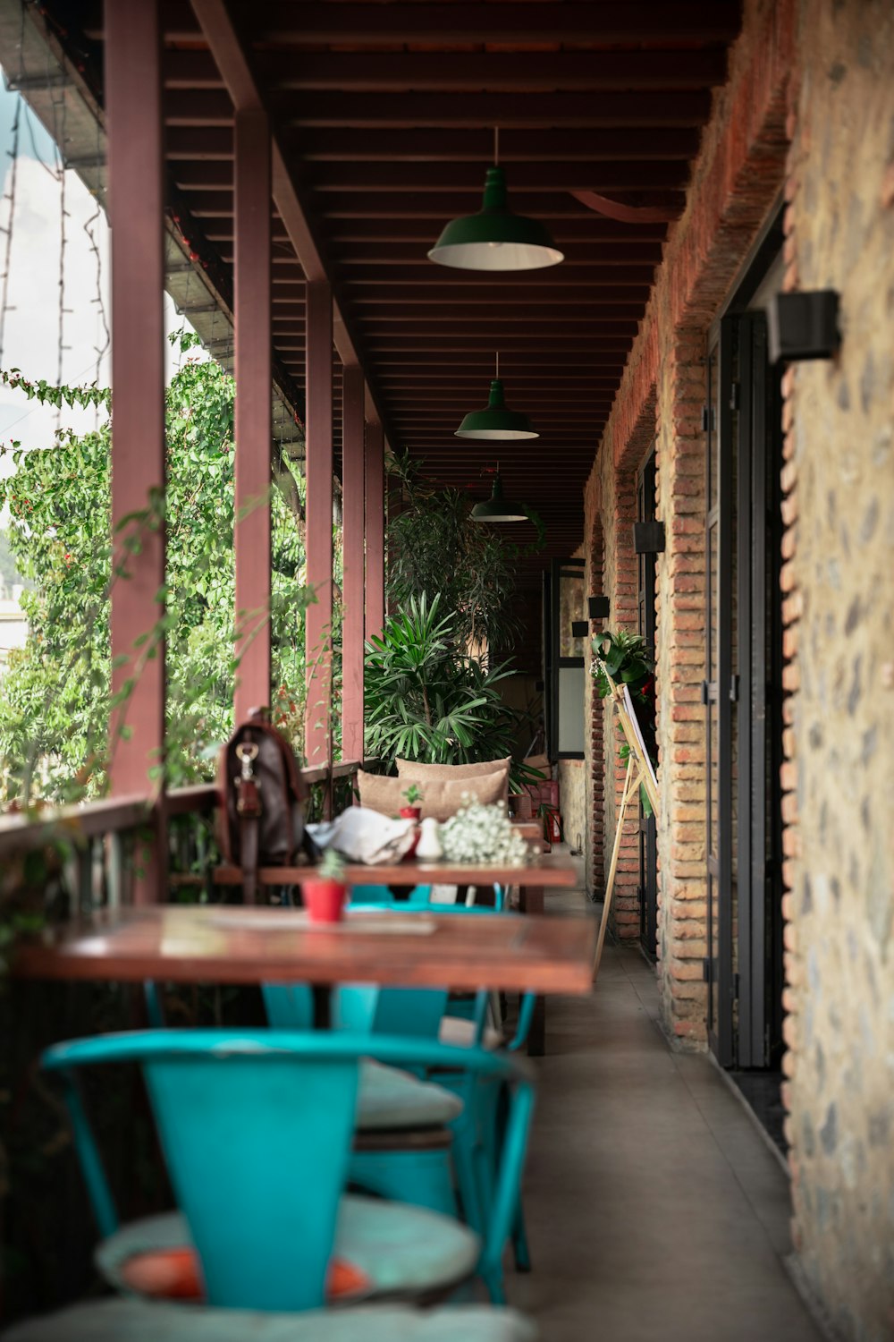 a long covered porch with tables and chairs