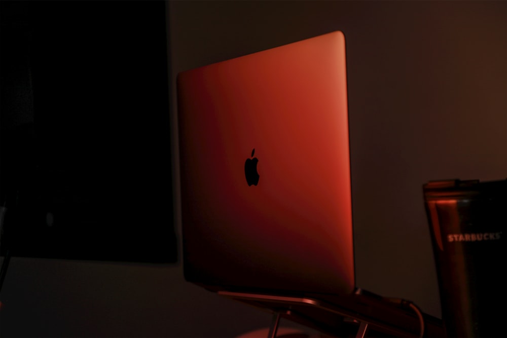 a red apple laptop sitting on top of a desk