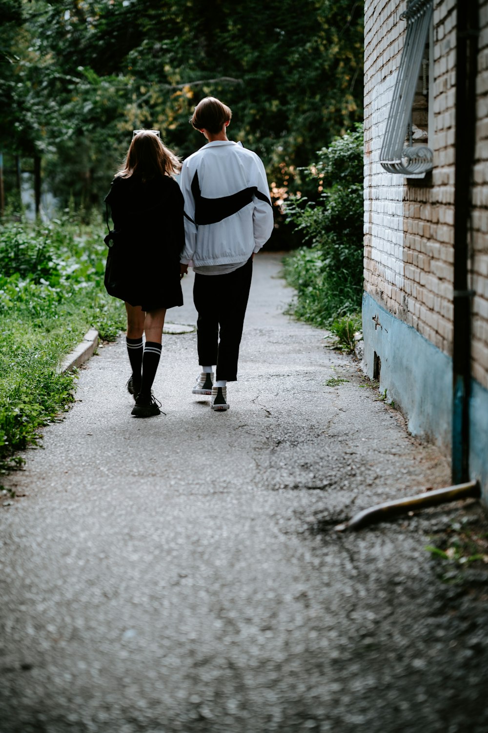 a man and a woman walking down a sidewalk