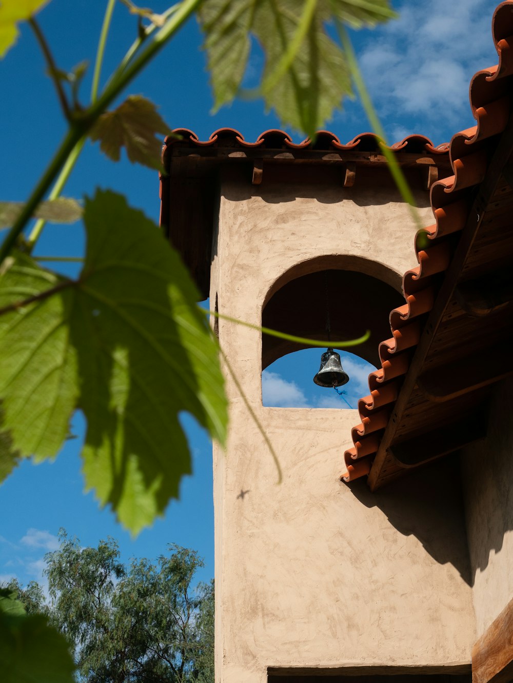 a clock tower with a bell on the side of it