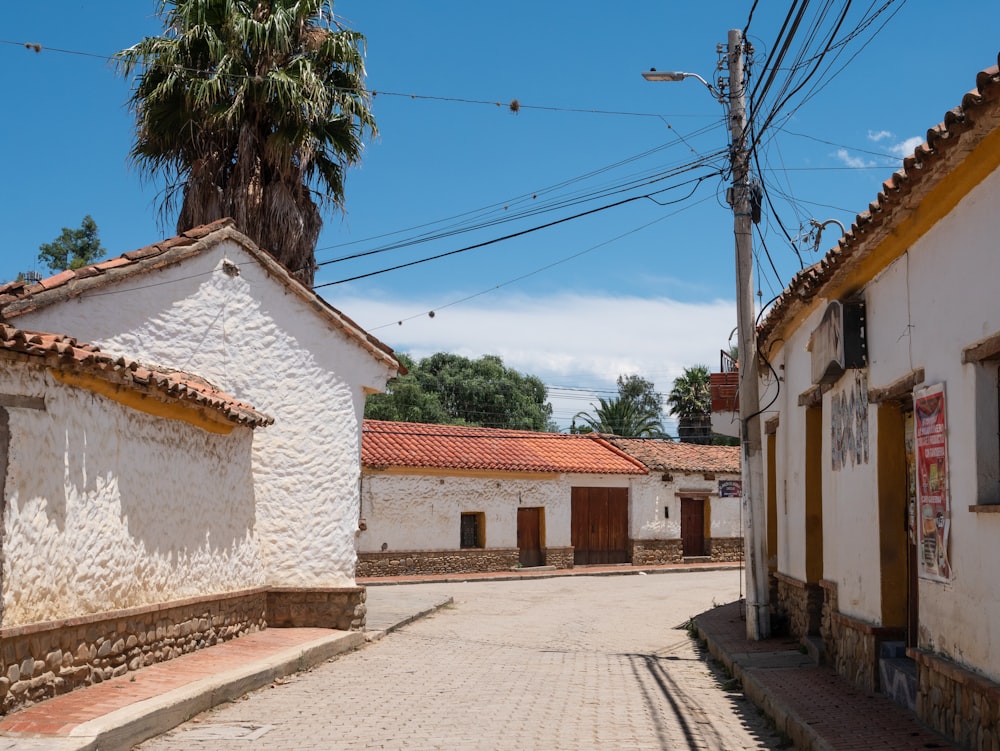 a street lined with white buildings and palm trees