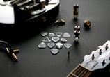 A collection of vinyl records, guitar picks, and merch laid out on a dark wooden table.