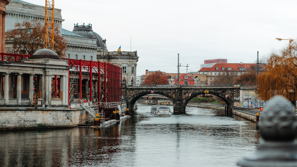 a boat traveling down a river next to a bridge