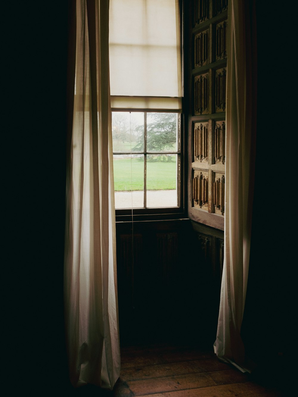 a room with a window and a book shelf