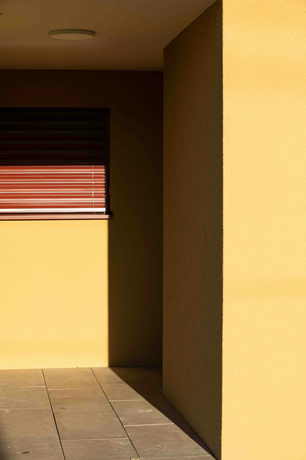 un bâtiment jaune avec une porte rouge et une fenêtre