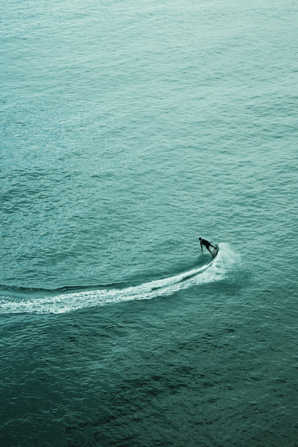 uma pessoa em uma prancha de surf montando uma onda no oceano