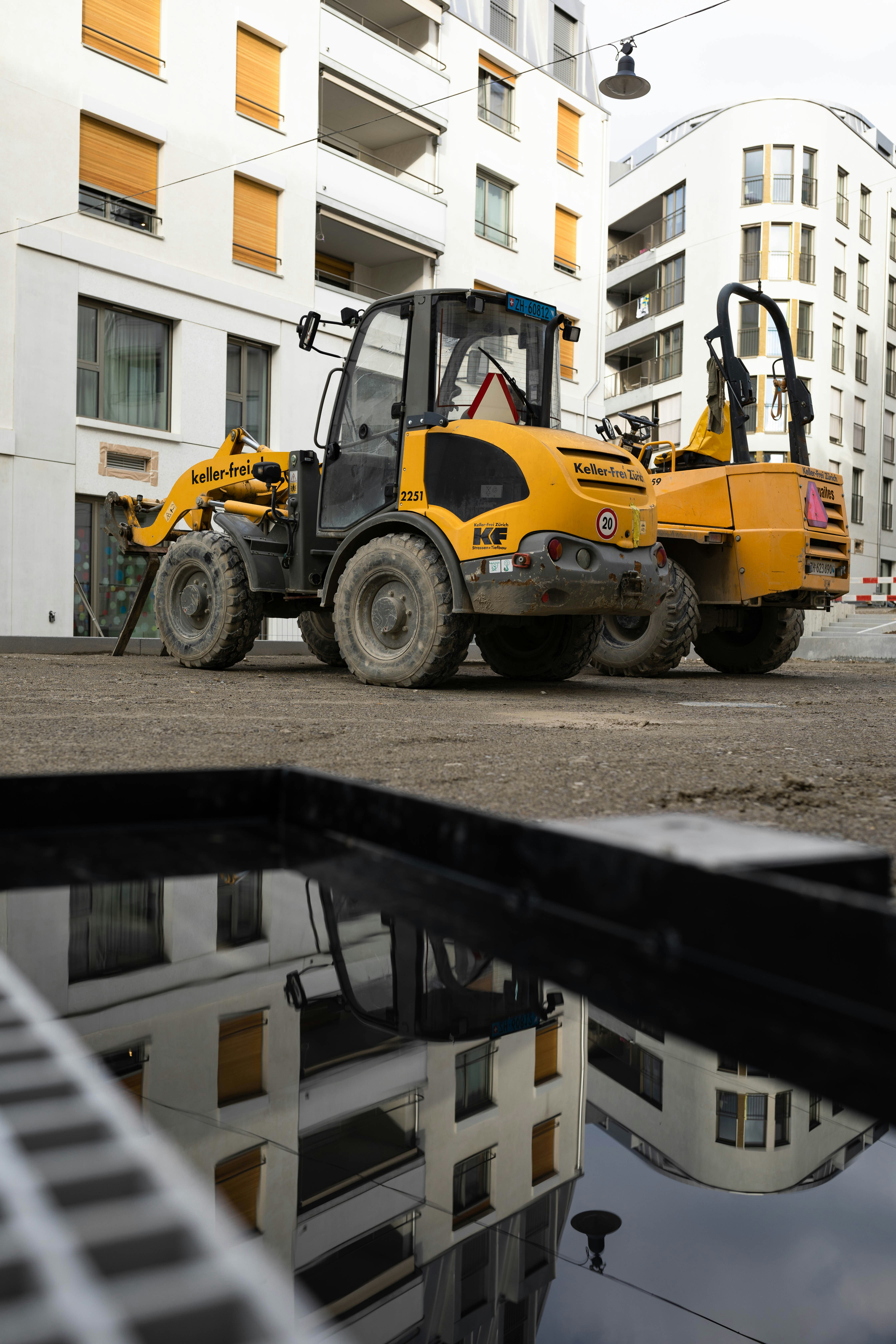 a construction vehicle parked in front of a building by Pascal Meier (@zhpix)