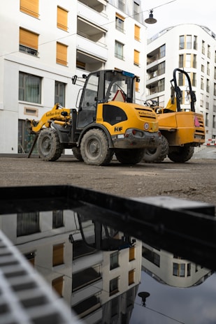 Close-up of a modern construction vehicle parked near a residential building under development.