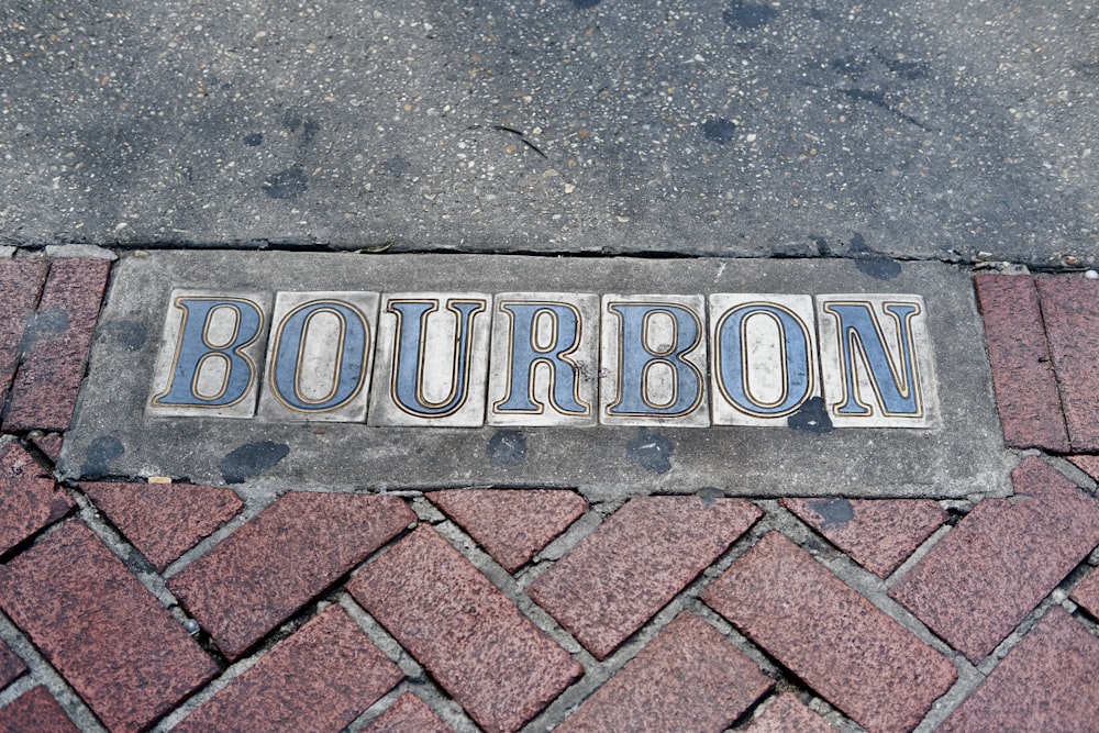 a sign that reads bourbon on a sidewalk