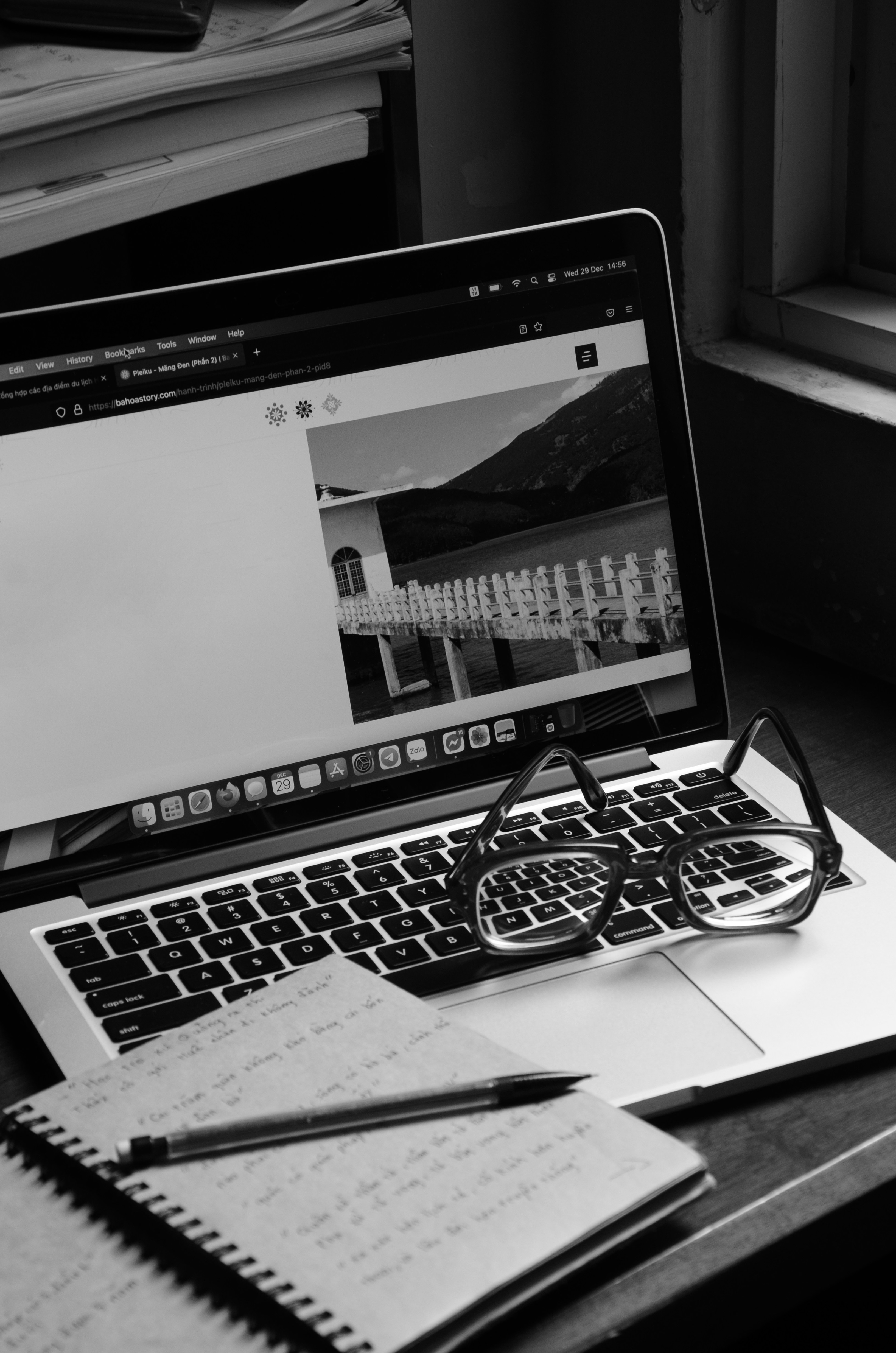 Person writing on a laptop in a cafe.