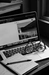 a laptop computer sitting on top of a wooden desk