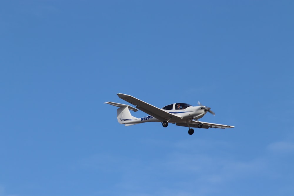 a small airplane flying through a blue sky