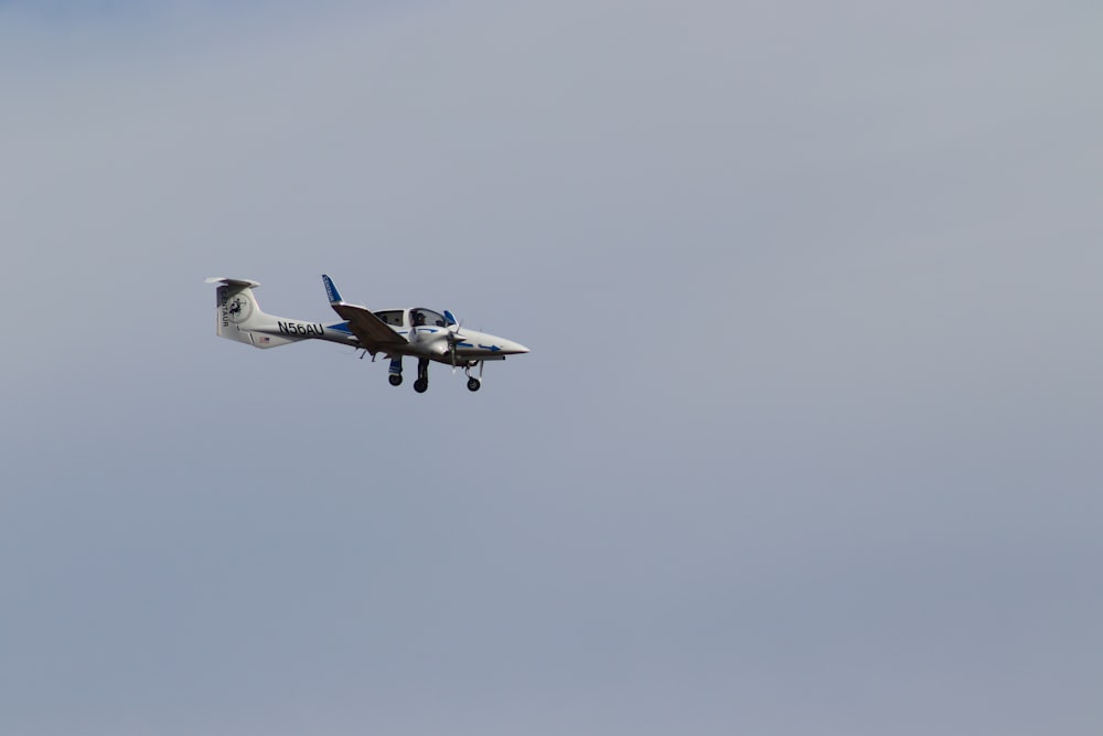 a small airplane flying through a blue sky