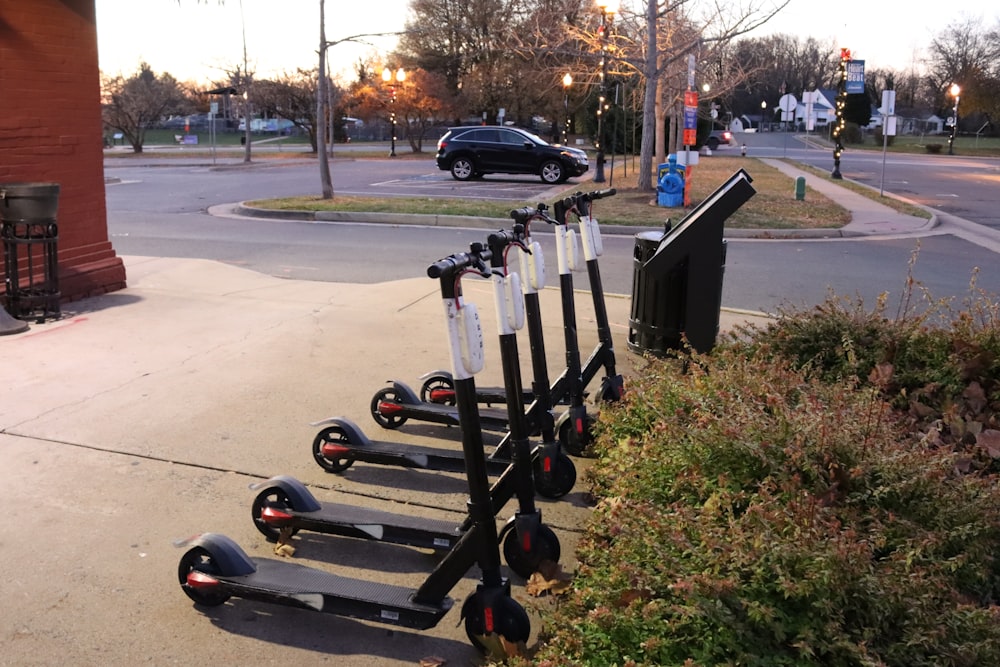 a row of scooters parked on the side of a road