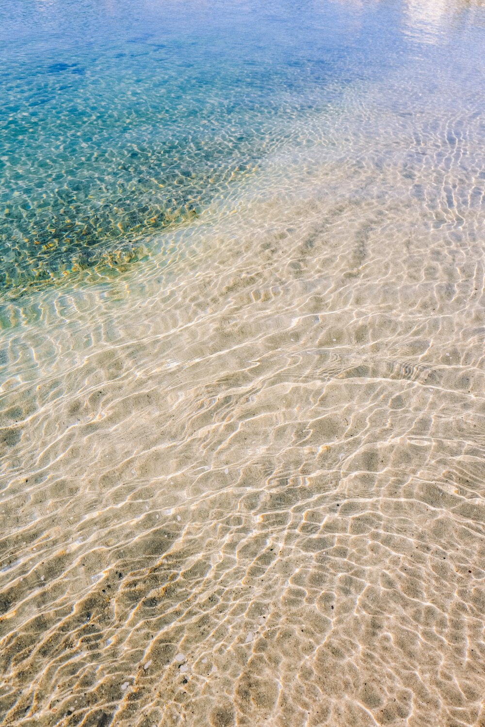 una playa de arena con agua azul clara
