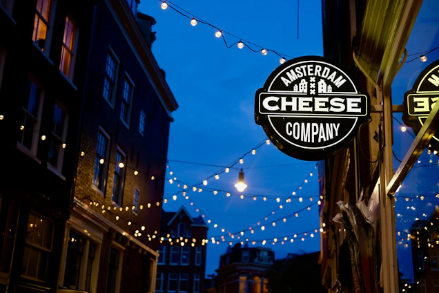Golden hour scene with friends sharing cheese and wine outdoors in Amsterdam’s cozy courtyard.