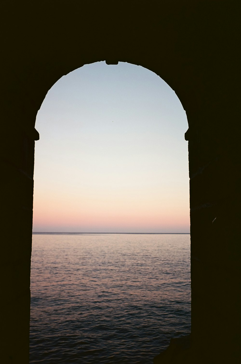 a view of a body of water through an arch