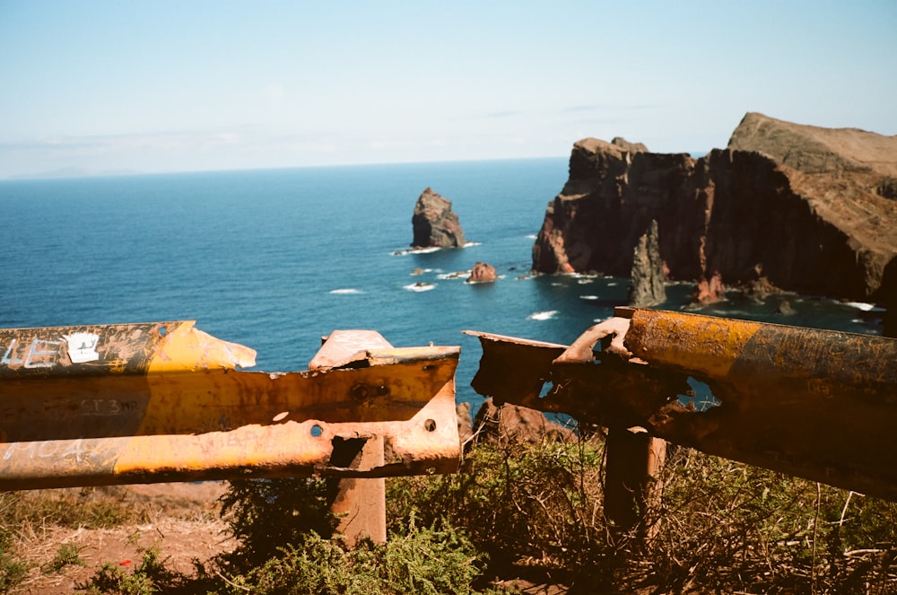 an old rusted metal railing overlooks the ocean