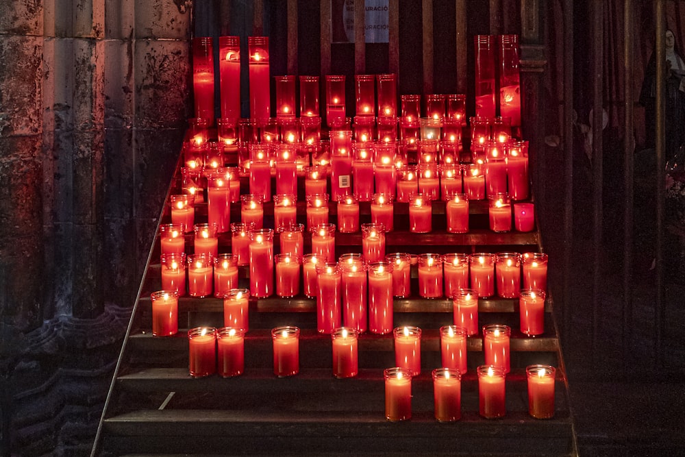 a group of red candles sitting on top of a set of steps