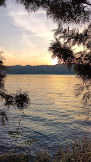 Sunset over a peaceful lake surrounded by trees, reflecting the warm colors of the Inland Empire evening.