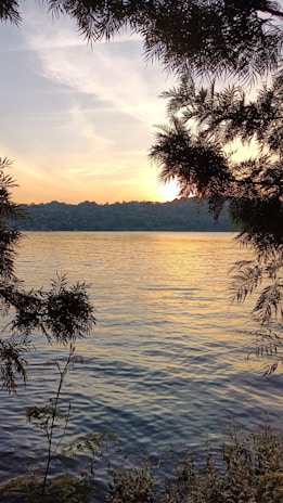 Sunset over a peaceful lake surrounded by trees, reflecting the warm colors of the Inland Empire evening.