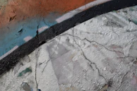 Close-up of worn textures on crumbling walls with graffiti and remnants of past performances.