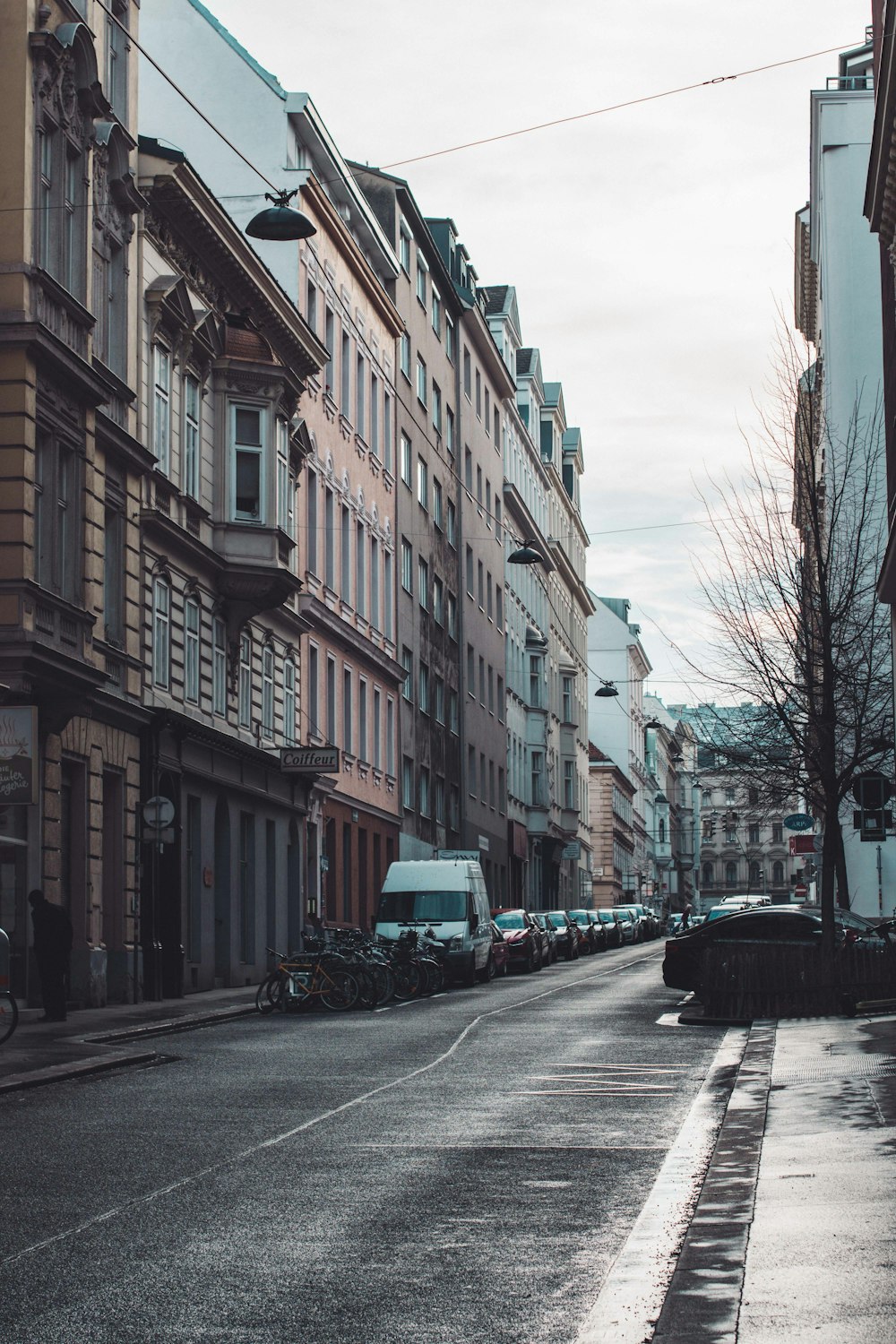 a city street lined with parked cars and tall buildings