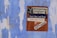 A weathered blue wall with peeling paint has a poster attached. The poster features text with motivational phrases such as 'Supercharge Your Future', 'Start, Run, and Grow', and 'Enough Said'. It includes the logo for ARTnews.