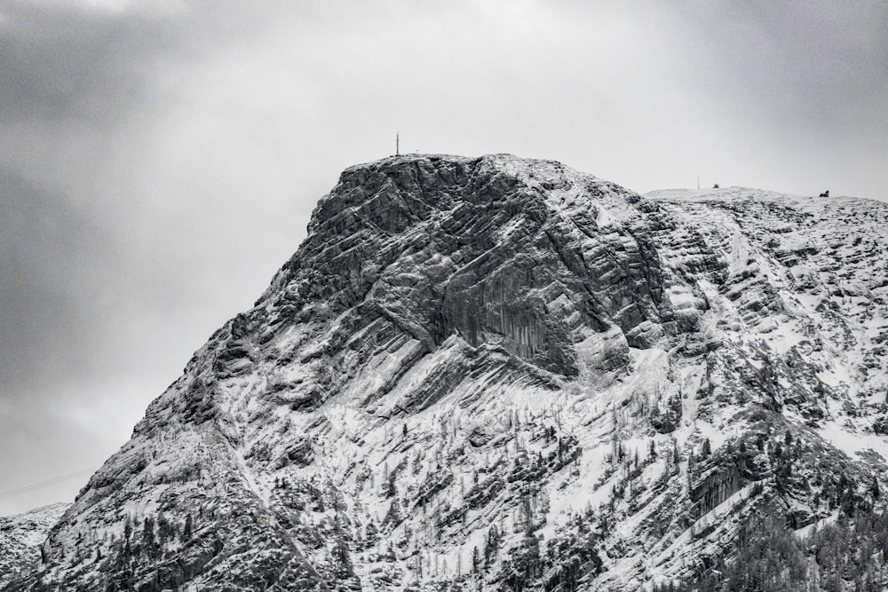 a mountain covered in snow under a cloudy sky